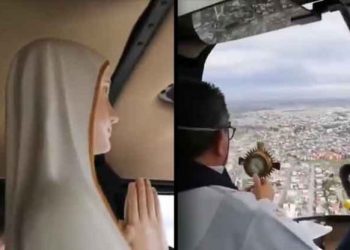 Sacerdote con mascarilla y acompañado de la figura de una virgen bendice a los ciudadanos de Chile desde un helicóptero