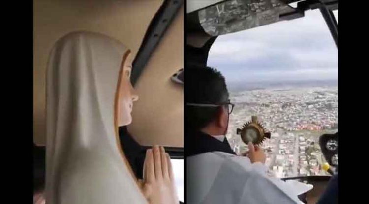 Sacerdote con mascarilla y acompañado de la figura de una virgen bendice a los ciudadanos de Chile desde un helicóptero