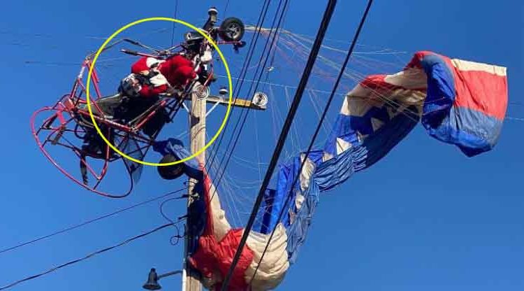 Santa Claus en paracaídas iba a dar el mensaje de Navidad pero queda enredado en cables de electricidad
