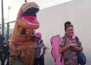 Joven se disfraza de dinosaurio para alegrar y acompañar a su madre a vacunarse contra el Covid-19