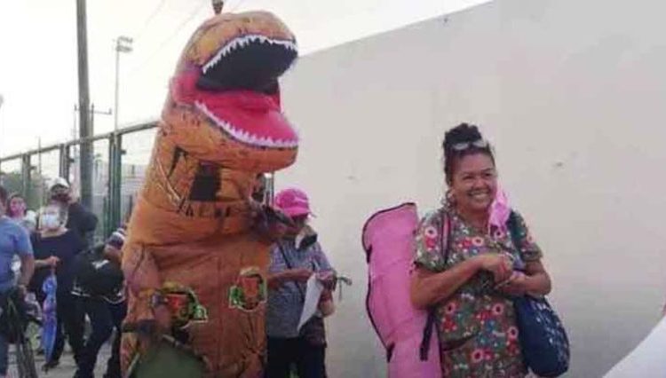 Joven se disfraza de dinosaurio para alegrar y acompañar a su madre a vacunarse contra el Covid-19