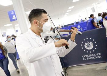 Doctor violinista deleita a personas que acuden a aplicarse la vacuna contra el COVID-19