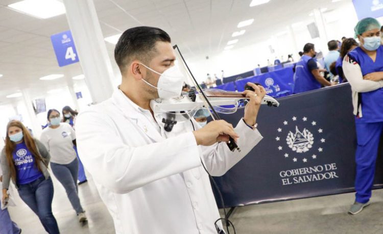 Doctor violinista deleita a personas que acuden a aplicarse la vacuna contra el COVID-19